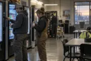 Workers using a vending area during a shift change in an industrial break room